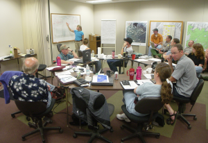 A group of people seated at a circular table during a meeting